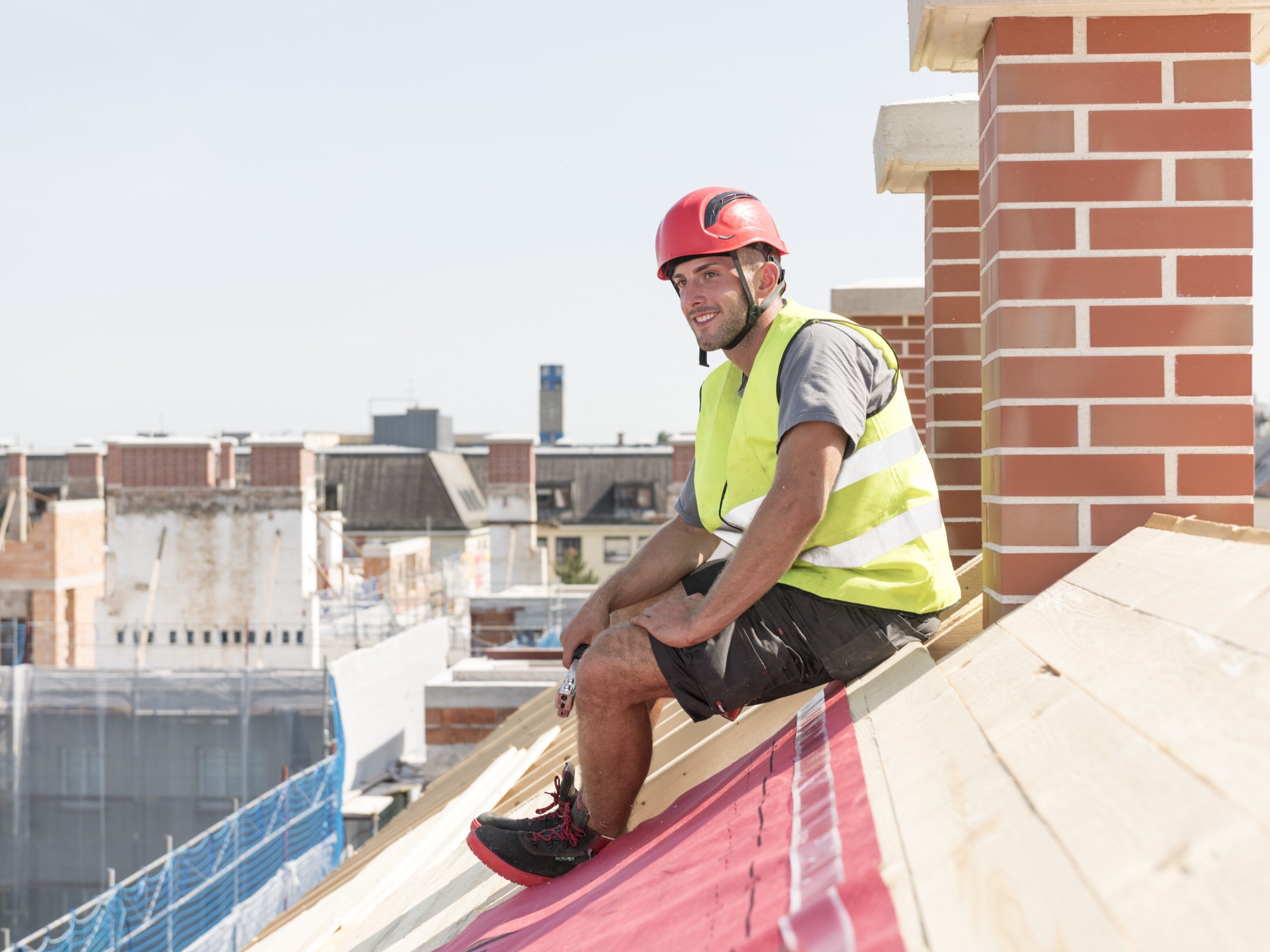Smiling roofer sitting on roof