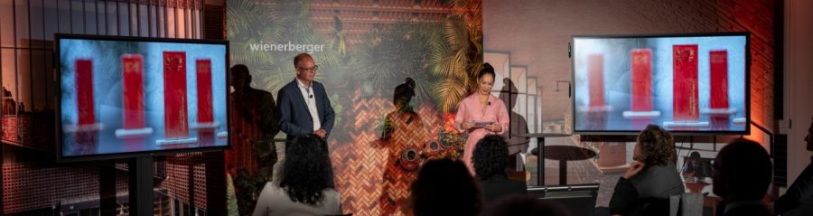 Heimo Scheuch and Miriam Hie at the Ceremony; trophies on screen