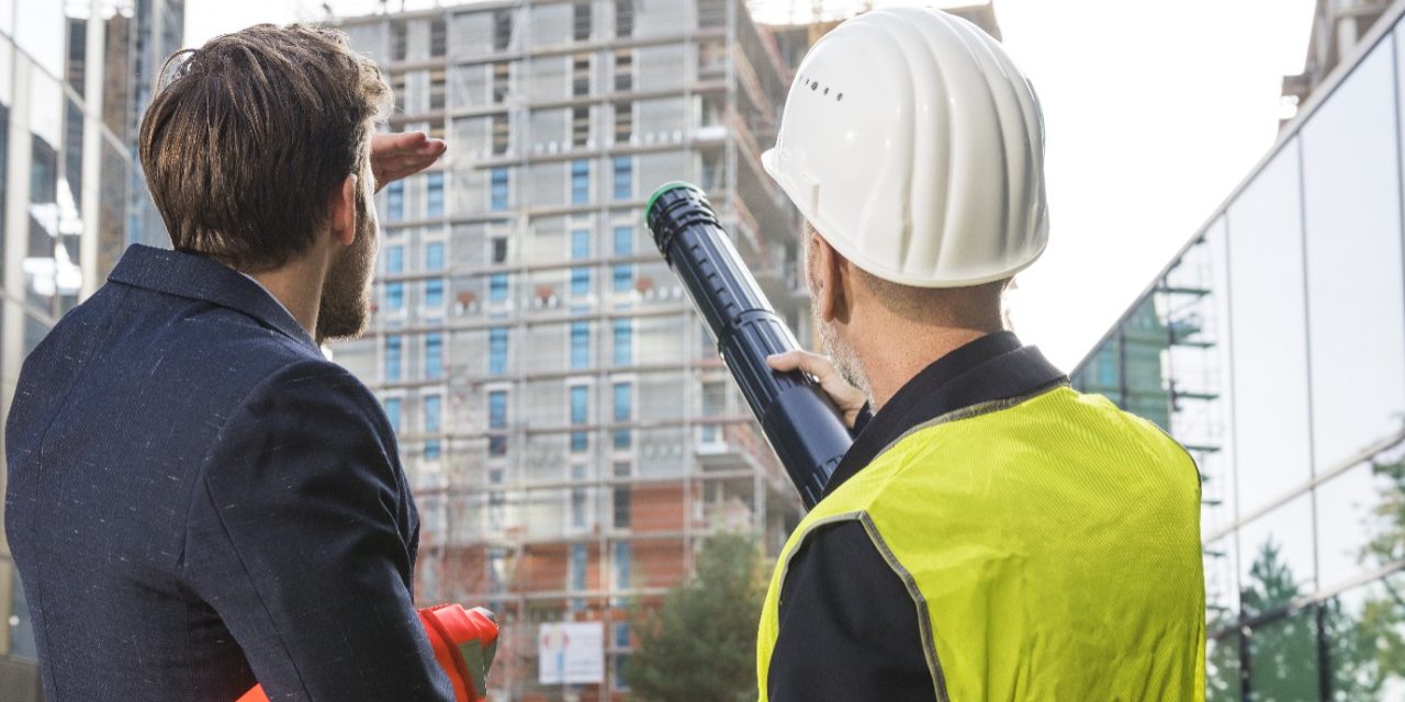 Businessman and architect talking about a new building project at a construction site