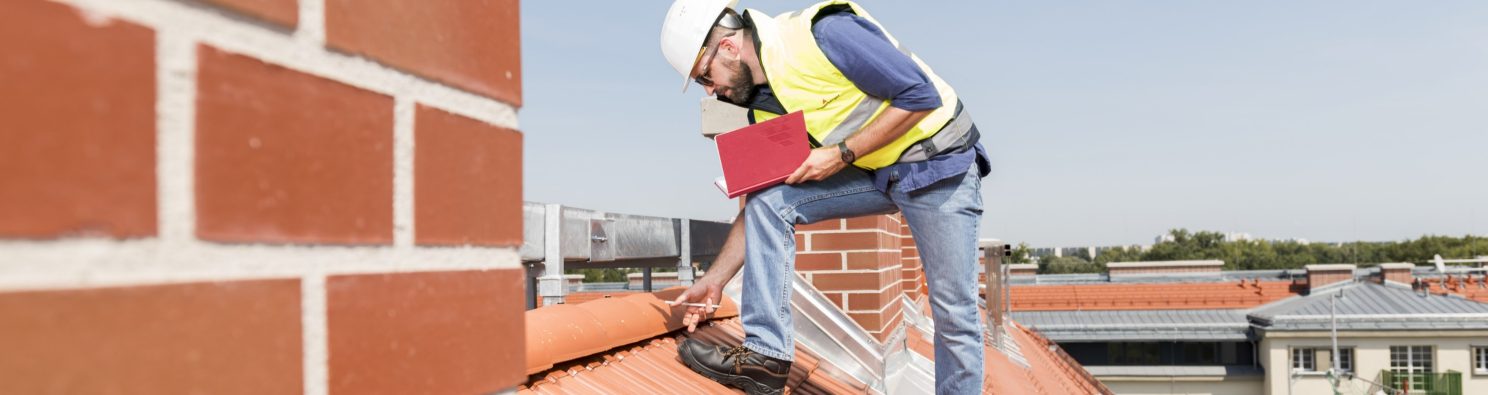 Urban roofer product manager checking ridge system wearing safety jacket and hard hat in an urban location